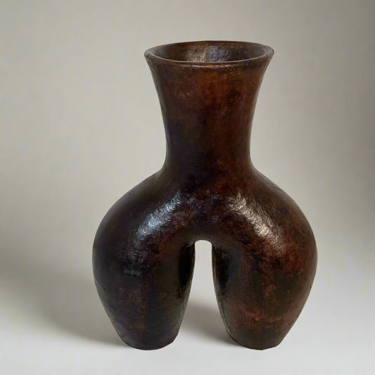 Bronze vase with a unique design on a textured surface
