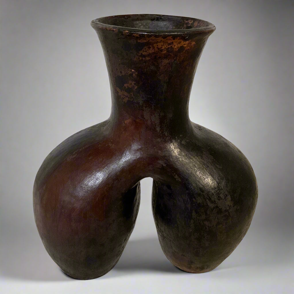 Brown ceramic vase with unique design on a light background